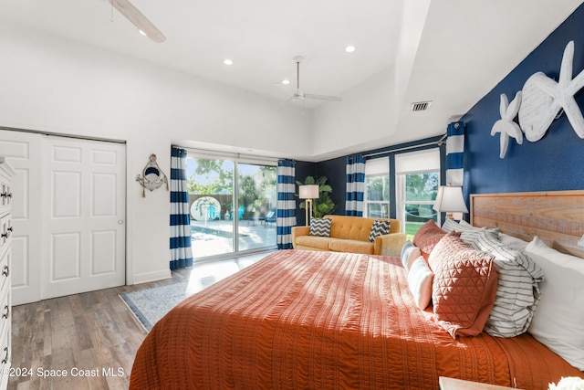 bedroom with access to exterior, ceiling fan, multiple windows, and hardwood / wood-style flooring