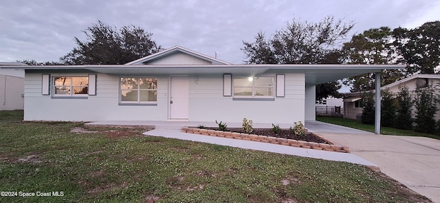 view of front of home with a front yard and a carport