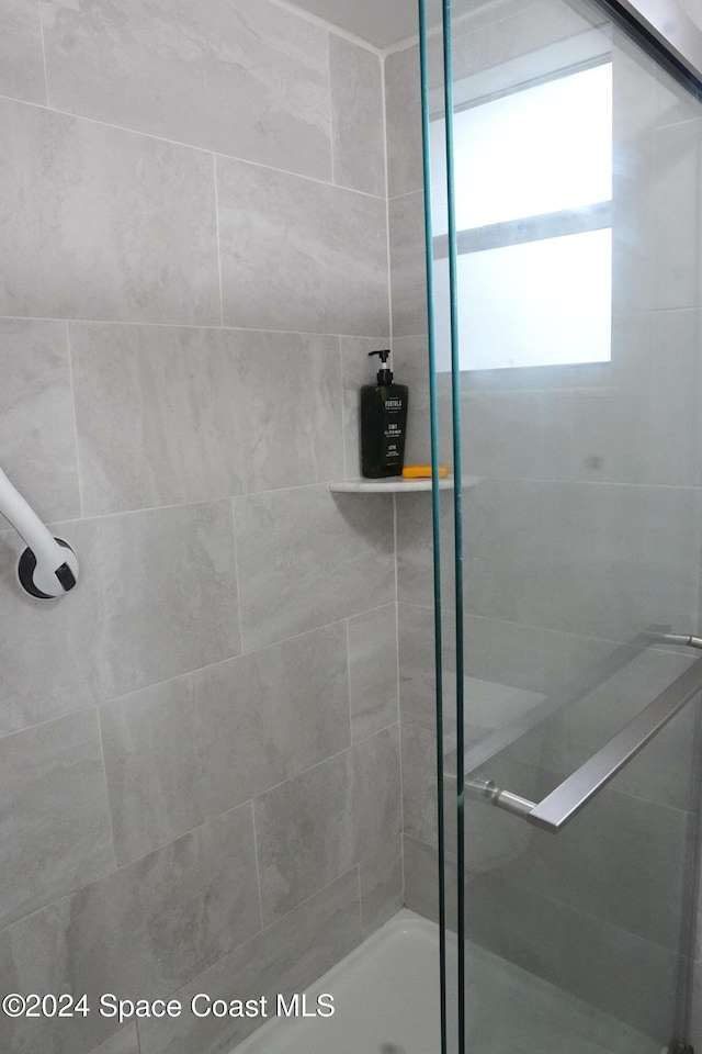 bathroom with a shower with door