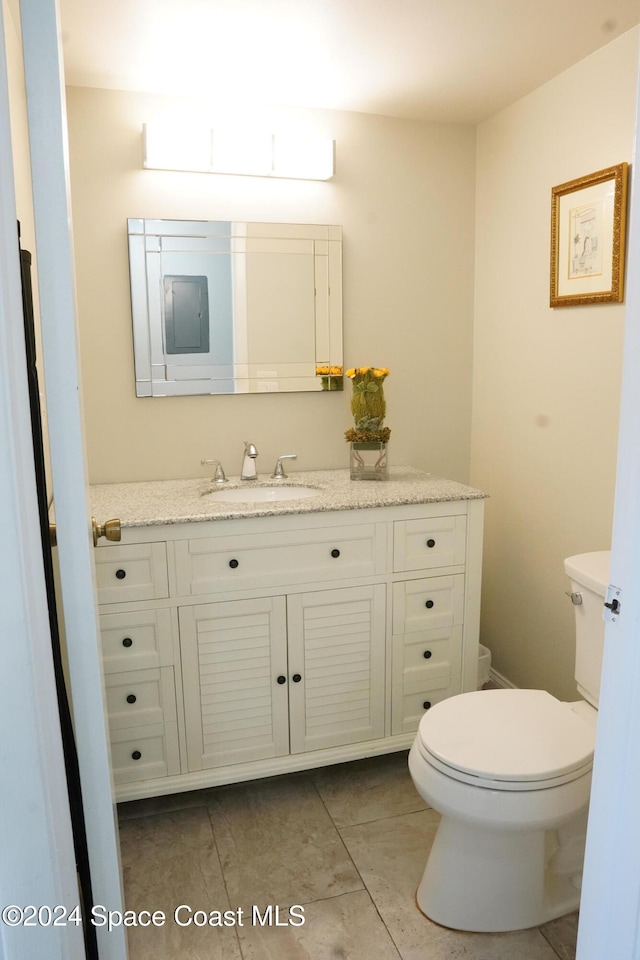 bathroom featuring tile patterned flooring, vanity, and toilet