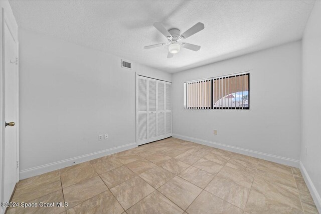 5800 N Banana River Blvd Unit 134, Cape Canaveral, FL 32920 - unfurnished bedroom with a ceiling fan, baseboards, visible vents, a closet, and a textured ceiling