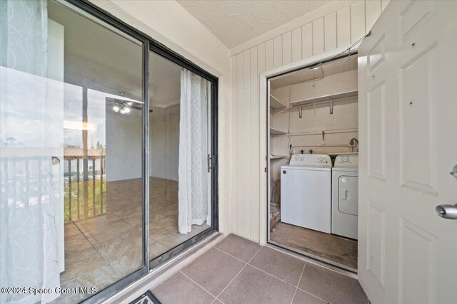 5800 N Banana River Blvd Unit 134, Cape Canaveral, FL 32920 - clothes washing area with washer and clothes dryer, wooden walls, tile patterned floors, and a textured ceiling