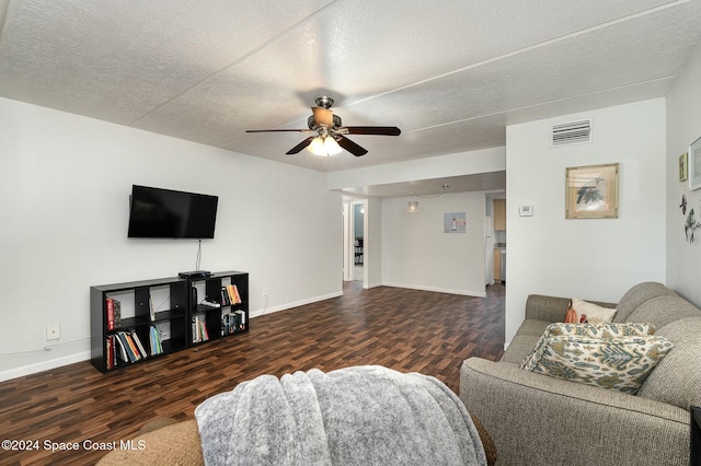 living room with ceiling fan, dark wood-type flooring, and a textured ceiling