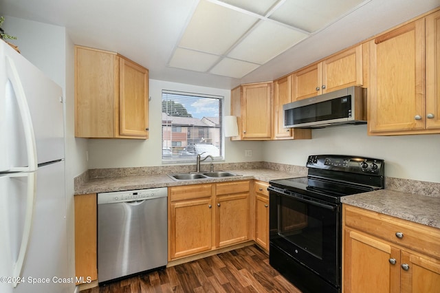 kitchen with appliances with stainless steel finishes, dark hardwood / wood-style flooring, light brown cabinetry, and sink