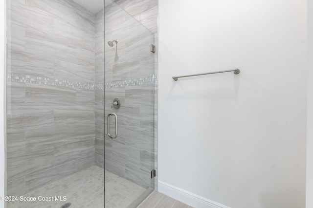 bathroom with a shower with door