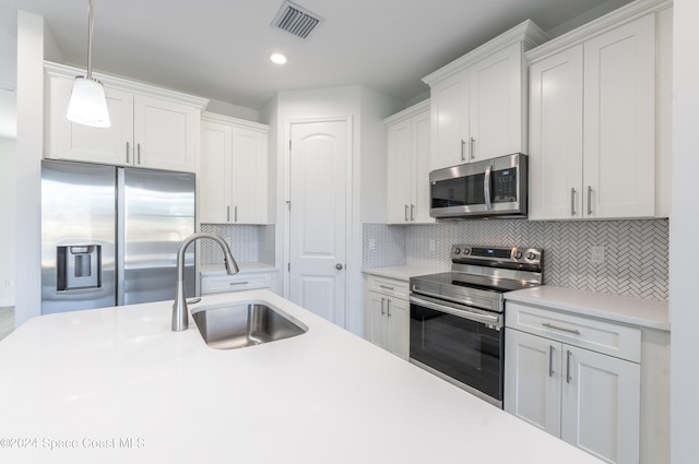 kitchen with white cabinets, sink, backsplash, and appliances with stainless steel finishes