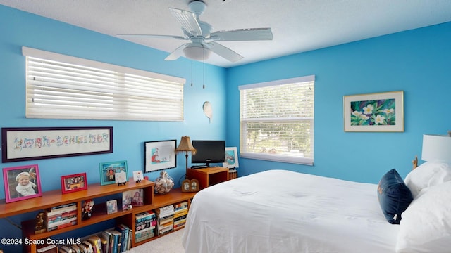 bedroom featuring carpet, a textured ceiling, and ceiling fan