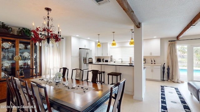 tiled dining area featuring beam ceiling, a textured ceiling, an inviting chandelier, and sink