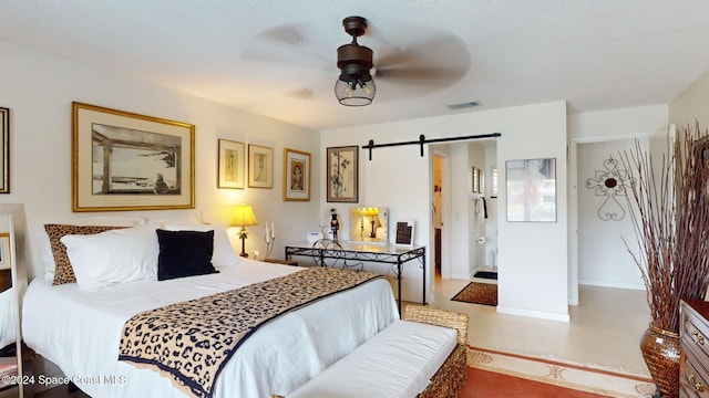 bedroom featuring a barn door and ceiling fan