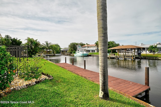 dock area with a water view and a yard