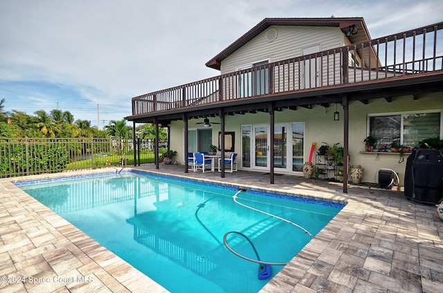 view of pool with ceiling fan, a patio area, and grilling area