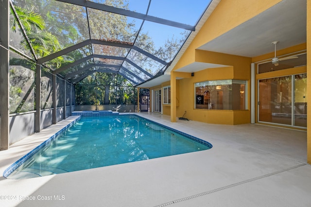 view of pool featuring glass enclosure, ceiling fan, and a patio