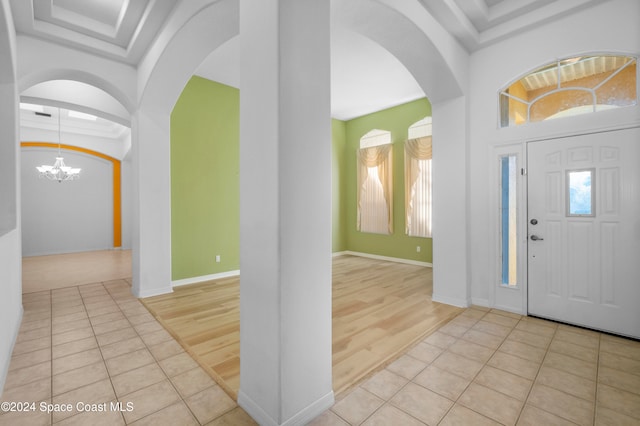 foyer with light wood-type flooring and a chandelier