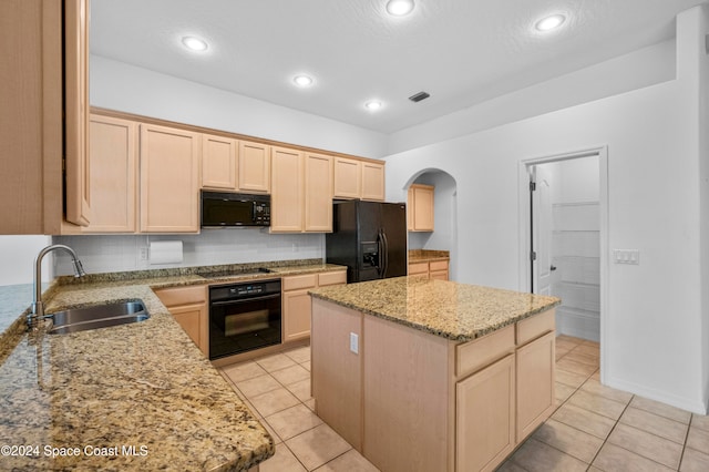 kitchen with black appliances, light brown cabinets, sink, and a center island