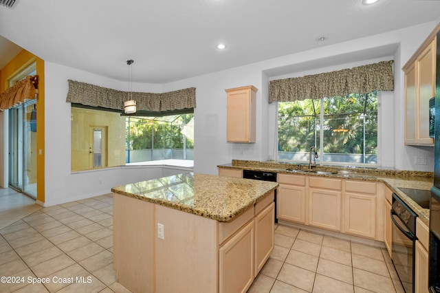 kitchen with plenty of natural light, black appliances, sink, and a kitchen island