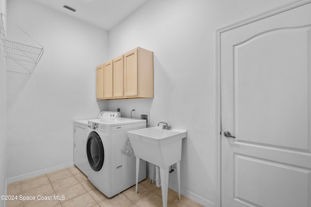 laundry area with separate washer and dryer, cabinets, and light tile patterned floors