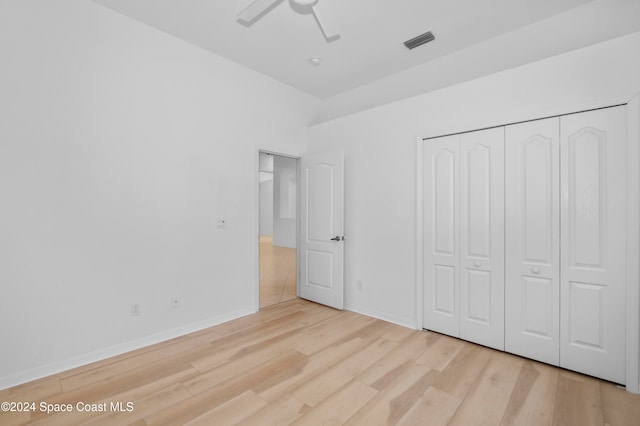 unfurnished bedroom featuring light wood-type flooring, ceiling fan, and a closet