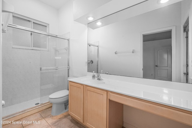 bathroom featuring toilet, vanity, tile patterned floors, and walk in shower