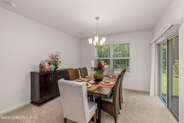 dining area with light carpet and a notable chandelier