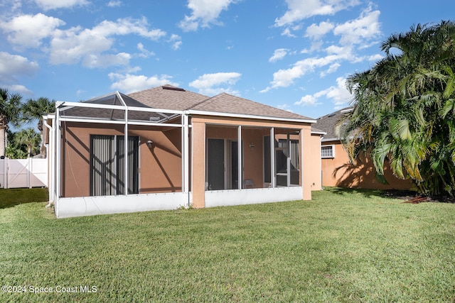 rear view of house with a yard and a lanai