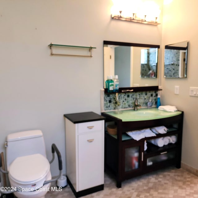 bathroom featuring vanity, tasteful backsplash, and toilet