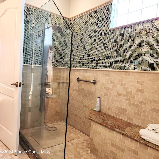 bathroom featuring a tile shower and tile walls