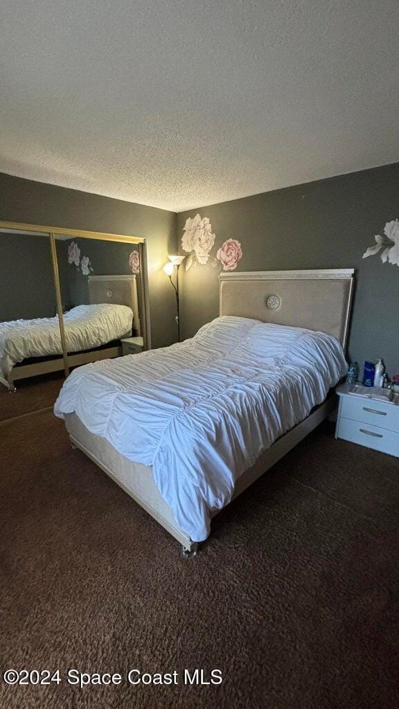 bedroom with a textured ceiling and carpet floors