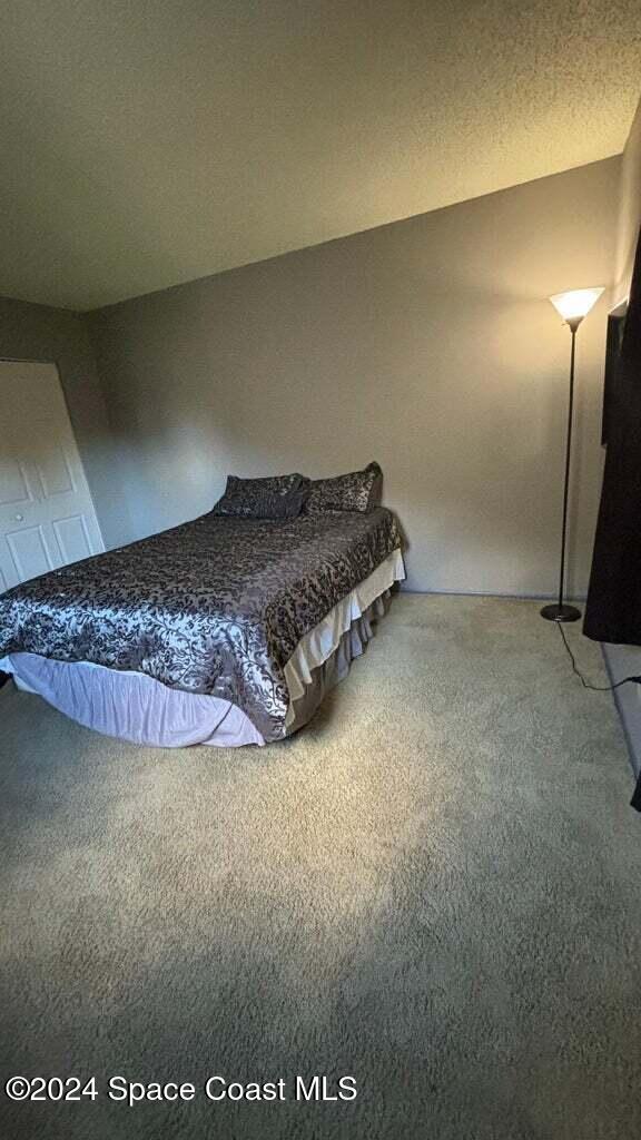 unfurnished bedroom featuring carpet and a textured ceiling