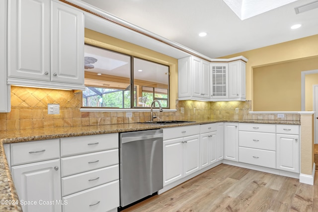 kitchen featuring dishwasher, sink, light hardwood / wood-style floors, light stone counters, and white cabinetry