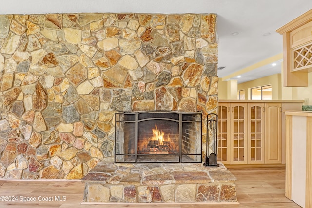 room details with a stone fireplace and hardwood / wood-style floors