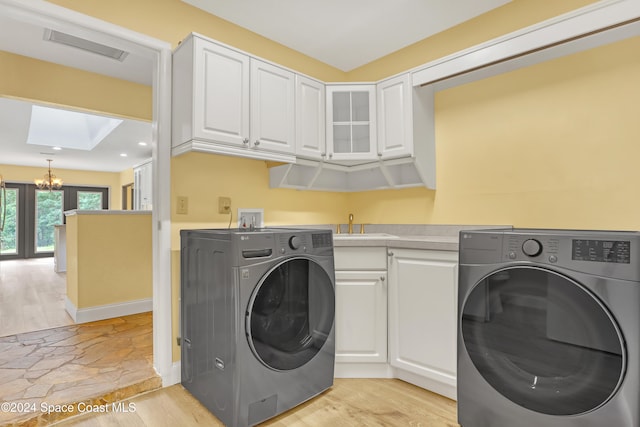 laundry area with washer hookup, a notable chandelier, light wood-type flooring, and a skylight