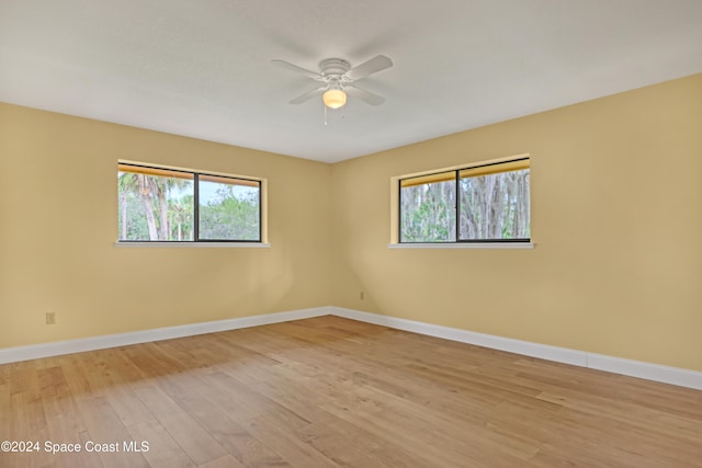 spare room with ceiling fan, plenty of natural light, and light hardwood / wood-style flooring