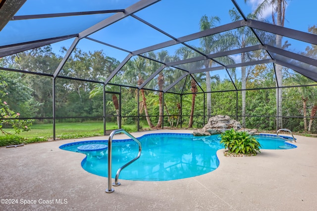 view of pool with a patio area and a lanai