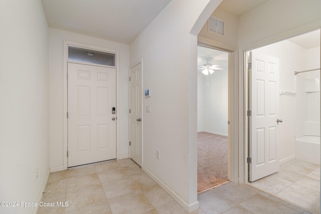 entrance foyer featuring ceiling fan and light colored carpet