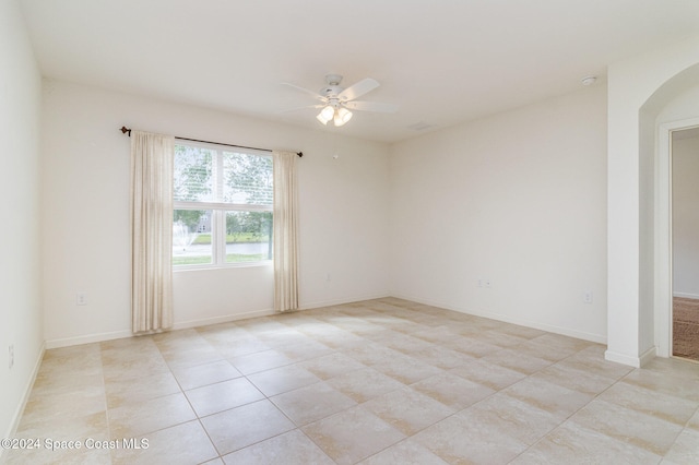 tiled empty room featuring ceiling fan