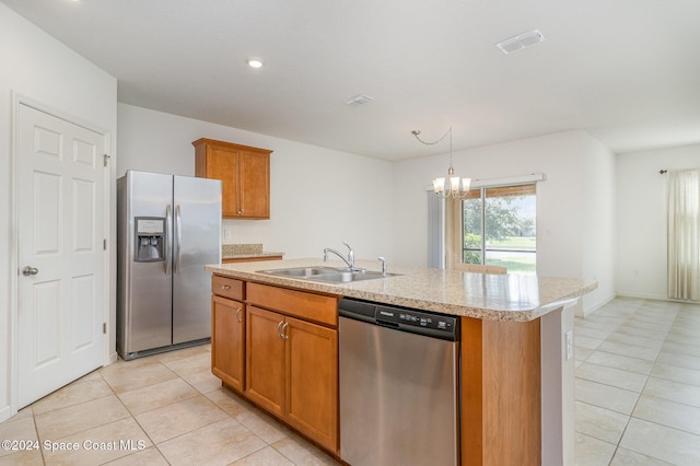 kitchen with light tile patterned flooring, sink, stainless steel appliances, and an island with sink