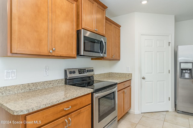 kitchen featuring light tile patterned flooring and appliances with stainless steel finishes