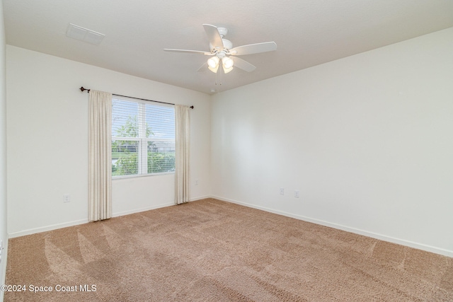 carpeted spare room featuring ceiling fan