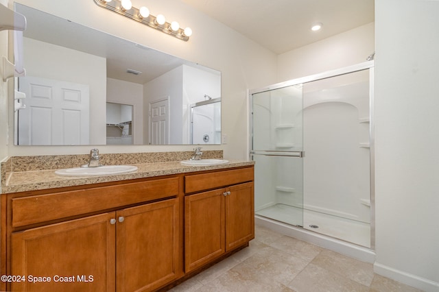 bathroom with tile patterned flooring, vanity, and a shower with shower door