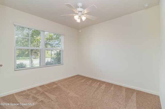 carpeted spare room with ceiling fan