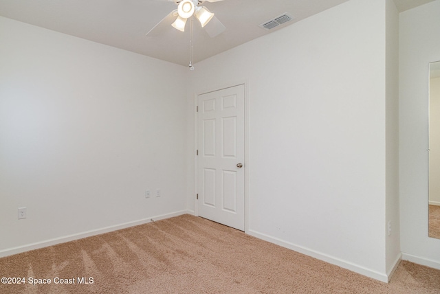 spare room featuring light carpet and ceiling fan