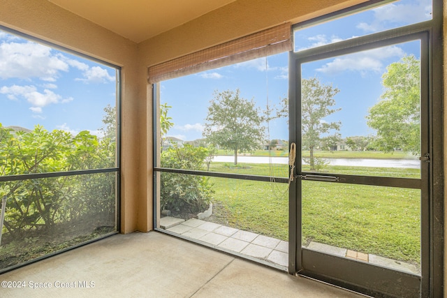 unfurnished sunroom featuring a water view