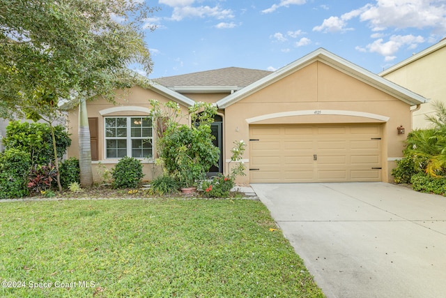 ranch-style house featuring a garage and a front lawn