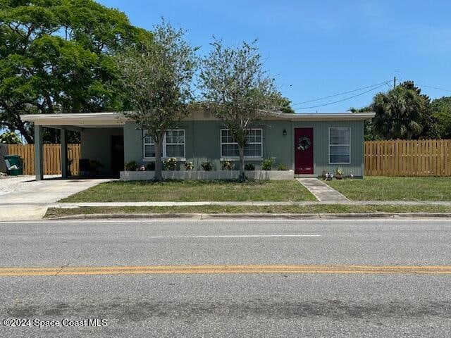 ranch-style house with a front yard and a carport