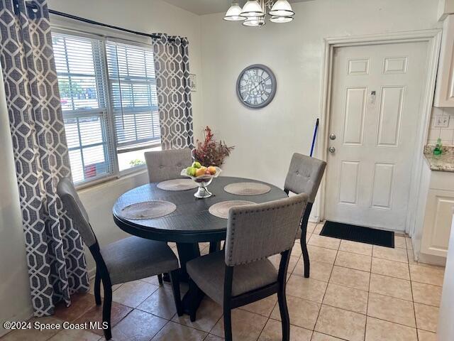 dining room featuring a chandelier, light tile patterned floors, and a healthy amount of sunlight