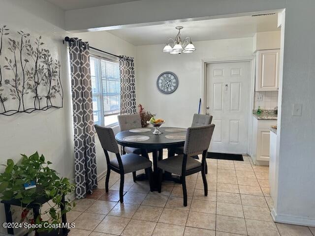 dining room featuring light tile patterned floors and a chandelier