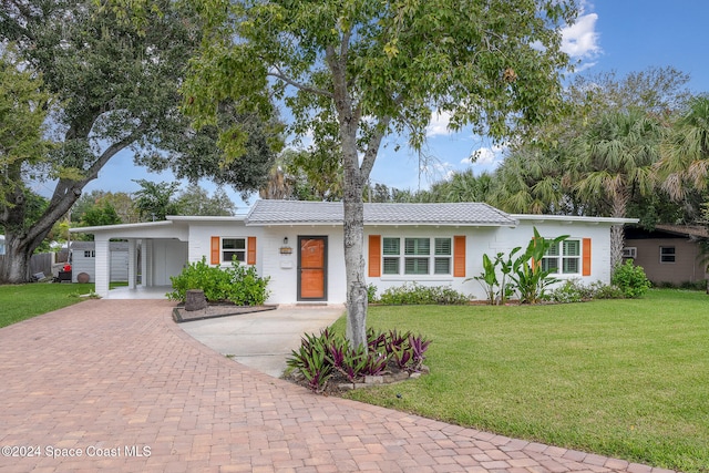 ranch-style house featuring a front lawn and a carport