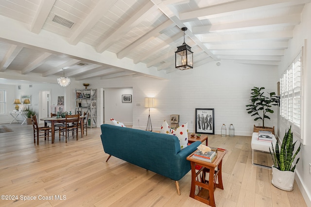 living room with vaulted ceiling with beams, a notable chandelier, and light hardwood / wood-style floors