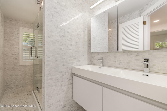 bathroom with vanity, a wealth of natural light, and tile walls