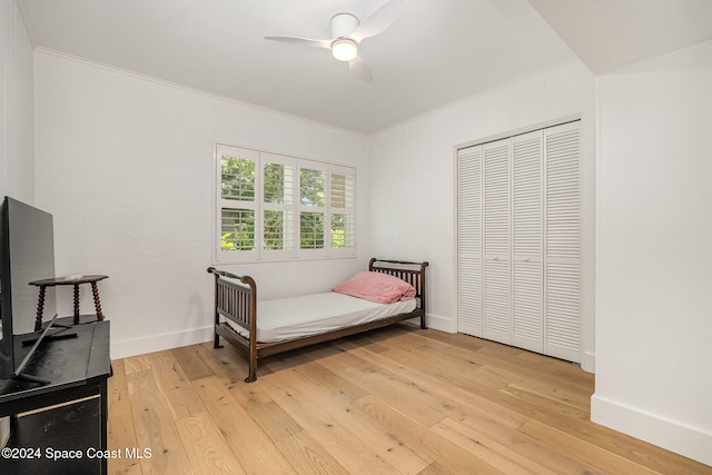 bedroom with light wood-type flooring, a closet, ceiling fan, and crown molding